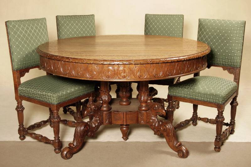 Tisch und vier Stühle, deutsch, um 1880, Eiche massiv, z.T. furniert, vier gedrechselte Säulen, 4-fach ausladend mit Greifvogelmotiv, Zarge mit ...