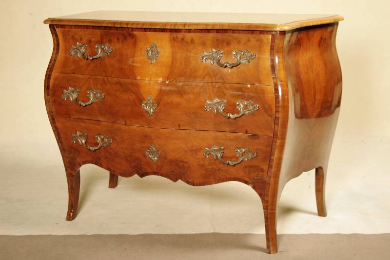 Barockstilkommode, Italien, 20/30er Jahre,, Nußbaufurnier, drei Schübe mit Bronzebeschlägen, geschweift, mit Alters- und Gebr.-spuren, kleinere ...