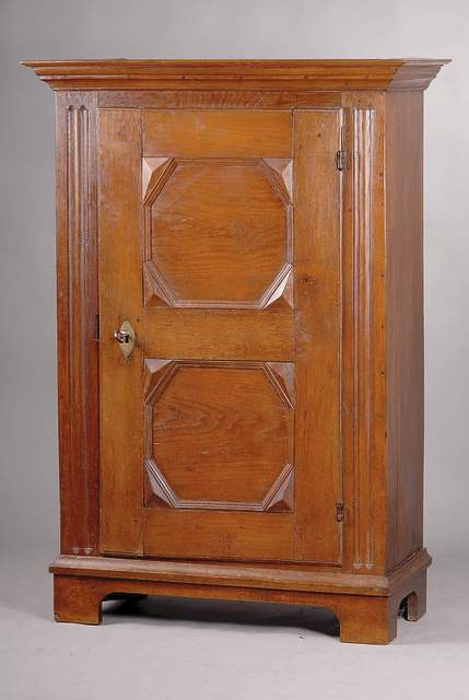 Eintüriger Bauernschrank, Hessen, um 1780/ 90, Eiche mass., Front auf Rahmen gearbeitet, Lisenen 4-fach liniert, Mittelteil gebogt, glatte ...
