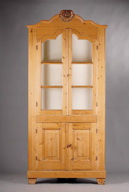 Eckvitrine, wohl mitteldeutsch, um 1860/70, WH massiv, Front auf Rahmen gearbeitet, 4 -türig, Oberteil verglast u. versprosst, 2 Einlegeböden, Kopf ...