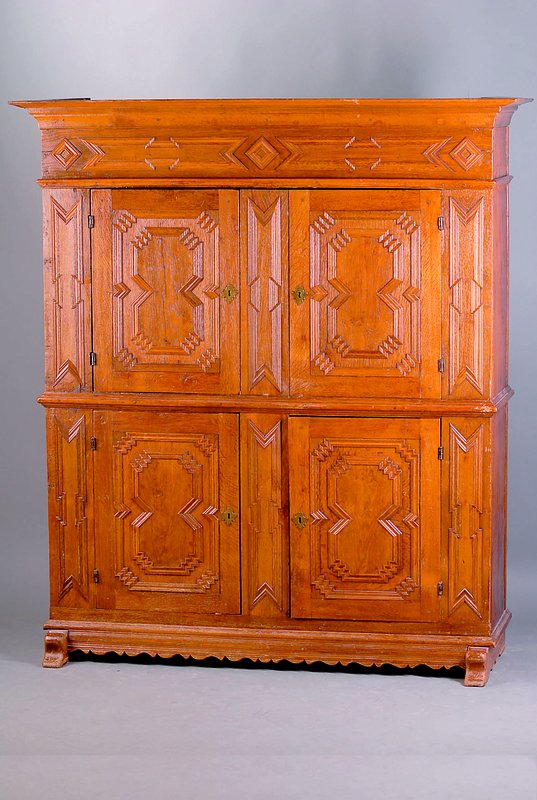 4-türiger Schrank, Westfalen um 1750/80, Eiche massiv, aufgesetzte Leistenschnitzereien i. Form v. Rosetten u. Rechtecken, z.T. vielfach verkröpfte ...