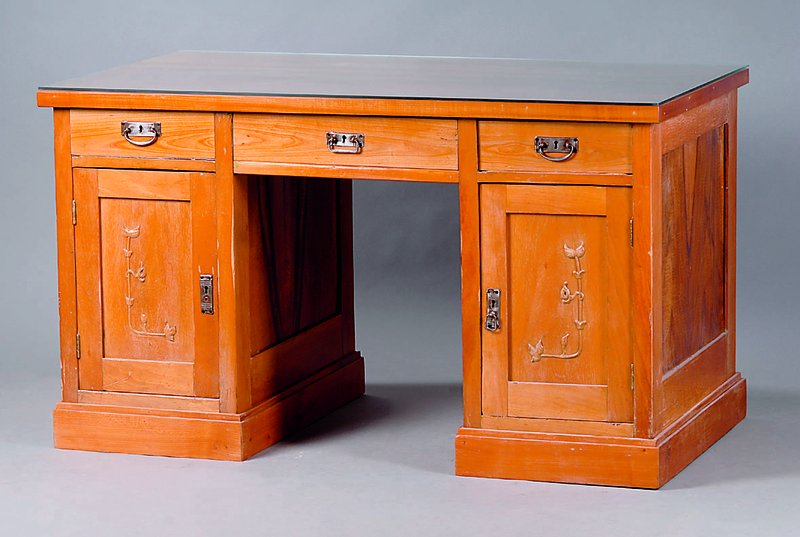 Schreibtisch, deutsch, um 1905, Kirschbaum massiv/Furnier, 3 Schubladen, 2-türig, diese m. sparsamer floraler Schnitzerei, Platte m. starkem ...