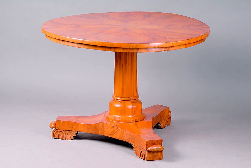 Tisch, Biedermeier, um 1830, Wurzelnußfurnier, auf der Platte mehrfach gesp. verlegt, 3 Auslegerbeine, Mittelsäule vielfach gerillt, Füße m. ...