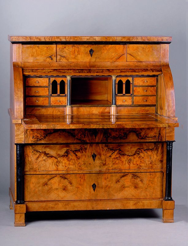 Zylinderbüro, süddeutsch, um 1820, Nußbaumwurzelfurnier, teil gesp. verlegt, Unterteil 3-schübig, reiche Inneneinrichtung, oberer Schub mit zwei ...
