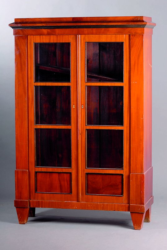 Vitrinenschrank, Berlin, um 1830-35, Korpus WH, Mahagonifurnier gesp. verlegt, orig. Gläser, Zierleisten z.T. geschwärzt, Kopf vielfach getreppt, 3 ...