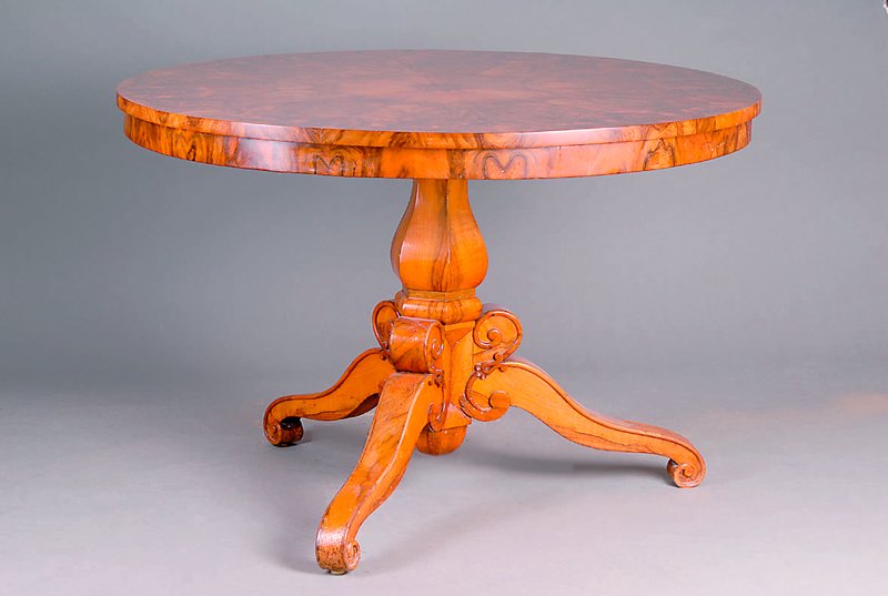 Runder Tisch, Frankfurter Raum, um 1825-30, Platte mit vielfach gespiegeltem Nußbaum- wurzelfurnier, 3 Auslegerbeine m Voluten, aufges. ...
