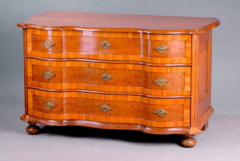 Barockkommode, wohl Pfalz, um 1760, Korpus WH Nußbaumfurnier/Eiche, doppelt geschweift, Kugelfüße, 3-schübig, aufgelegtes Nußbaumfries, ...