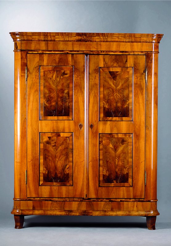 Biedermeierschrank, Umkreis Würzburg, um 1830, Nußbaum mass., kassettiert, Boden mit 2 Fächern, getreppte Inlets m. Wurzelnußfurnier, vielfach ...
