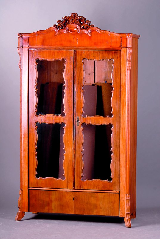 Vitrine, süddeutsch, um 1835/40, Kirschb., 2-türig, Brezelfüllungen, Kopf geschnitzt, st.Gebr.-Sp., alt belassen, Furniersch., schwundrissig, ...