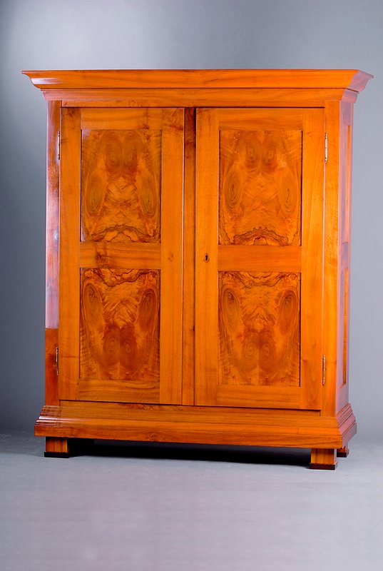 Biedermeierschrank, badisch, um 1810/20, Nußbaum massiv, mit 8 Kassetten ausgesuchtes symetr. Furnierbild, Einlagen mit lebendigem Wurzelnuß, reich ...