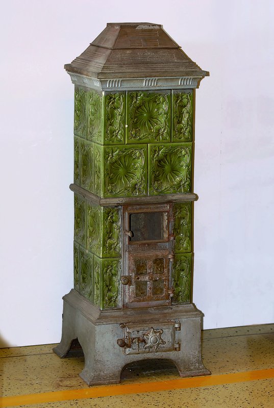 Jugendstil-Ofen, wohl Frankreich, um 1900/10 , Gußeisen, im abstarkten Jugendstil, mit grün glasierten floral reliefierten Kacheln, im frühen ...