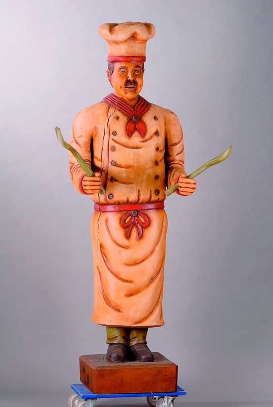 Werbefigur, Asien, ca. 20-30 Jahre alt, Holz, bunt bemalt, in Form eines Kochs, spannungsrissig, l. Altersspuren, mit Löffel und Gabel, H. 200 cm