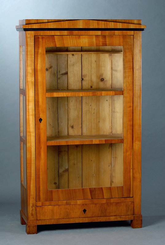 Vitrine, Biedermeier, um 1820, Kirschbaum, 1türig, 3 Seiten verglast u. versprosst, obere Zierleiste geschwärzt, Kopf getreppt, 2 feste ...