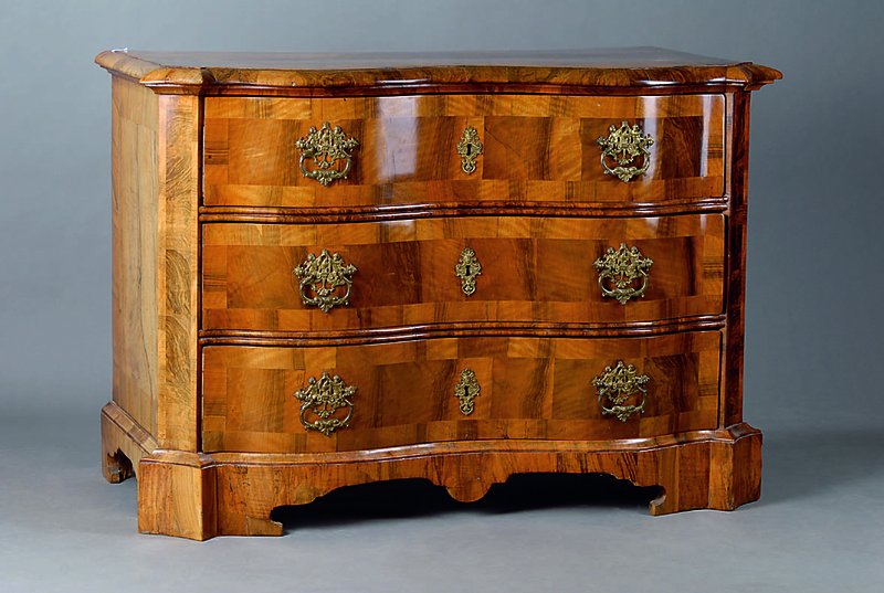Doppeltgeschweifte Kommode, wohl Braunschweig, um 1740/50, WH/Wurzelnußfurnier gesp. verlegt, 3-schübig, allseitig geschweift, Ecken abgeflacht u. ...