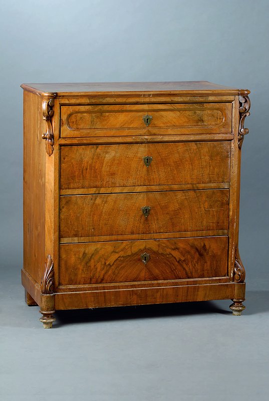 Kommode, norddeutsch, um 1850/60, Wurzelnußfurnier, 4-schübig, abgeflachte Ecken, sparsame Schnitzereien in Form v. Akanthusblättern, Reste alten ...