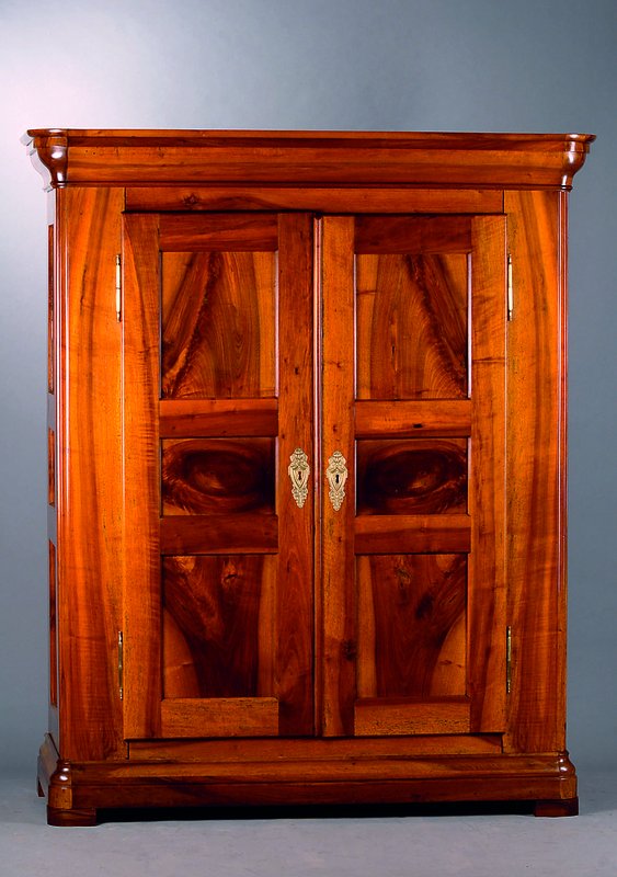 Schrank, deutsch, um 1800-1820, Nußbaum/Wurzelnußfurnier, Front u. Seiten kassettiert, abgerundete Ecken, Kopf vielfach getreppt, Fuß passig, ...