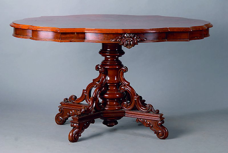 Ovaler Tisch, deutsch, um 1880/90, Mahagoni,4-Kantfuß, reich geschnitzt, in Form v. Akanthusblättern u. Voluten, gedrechselt, Platte geschweift u. ...