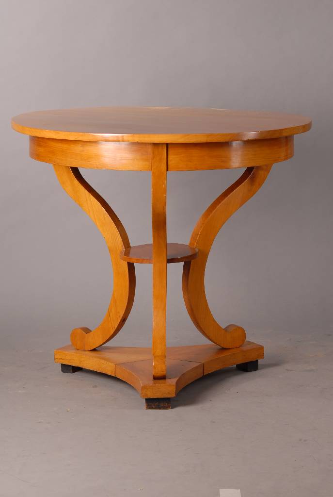 Runder Tisch, deutsch, um 1820, Platte erneuert, 3-Kantfuß, Kirschbaum, geschweift, Volutenverz., 1 Zwischenbrett, Gebr.-Sp., rest., H. 80 cm, D. 88 ...