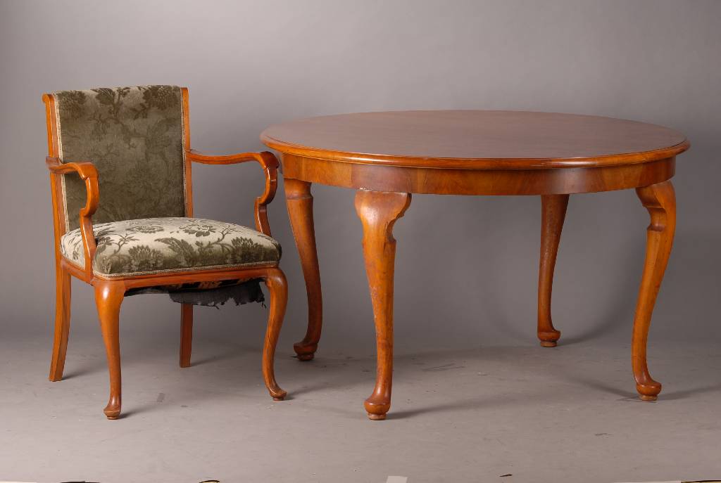 Sitzgruppe, best. aus Tisch u. 4 Armlehnsessel, um 1910, wohl Niederhöfer, Nußbaum, runder Tisch: Beine geschweift, sparsame Schnitzereien, Stühle ...