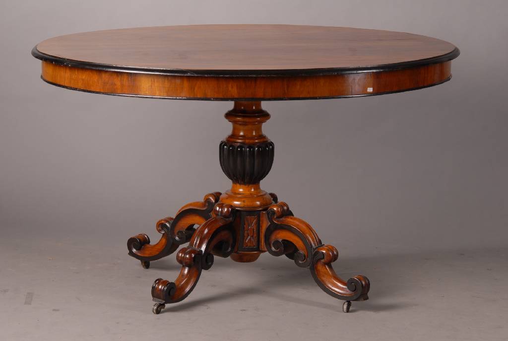 Nußbaumtisch, wohl Belgien, um 1860, Wurzelnuß, Zierteile geschwärzt, Balusterschaft, reich geschnitzt, Volutenverz. sparsame Blütenschnitzerei, ...