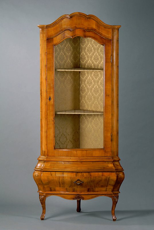 Eckvitrine, Dresdner Barockstil, Nußbaum, allseitig geschweift, Unterteil bombiert, 1 -schübig, 1 Glastür, 2 Einlegebretter, sparsame ...