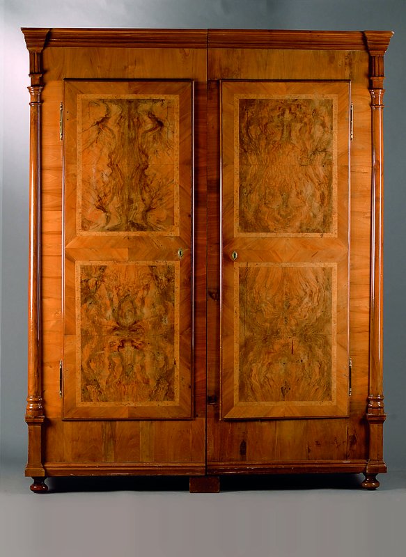 Schrank, wohl Freiburg, um 1770/80, Wurzelnuß, 2-türig, Lisenen als 3/4 Säulen, Kopf reich getreppt, Fuß passig, Schlösser sek., schwundrissig, ...