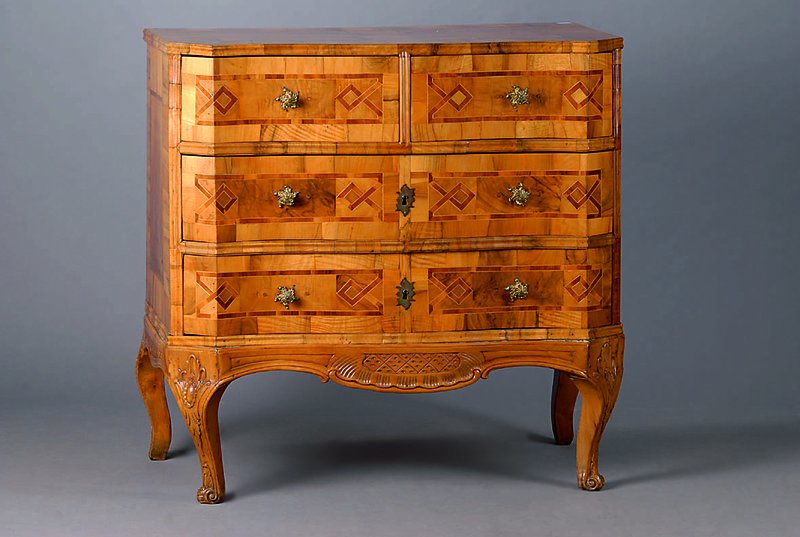 Kommode, Italien, um 1770/80, Nußbam/Wurzelnuß, 4-schübig, Ahornintarsien, Akanthusblattschnitzerei, schwundrissig, st. Gebr.-Sp., Fuß sekundär ...