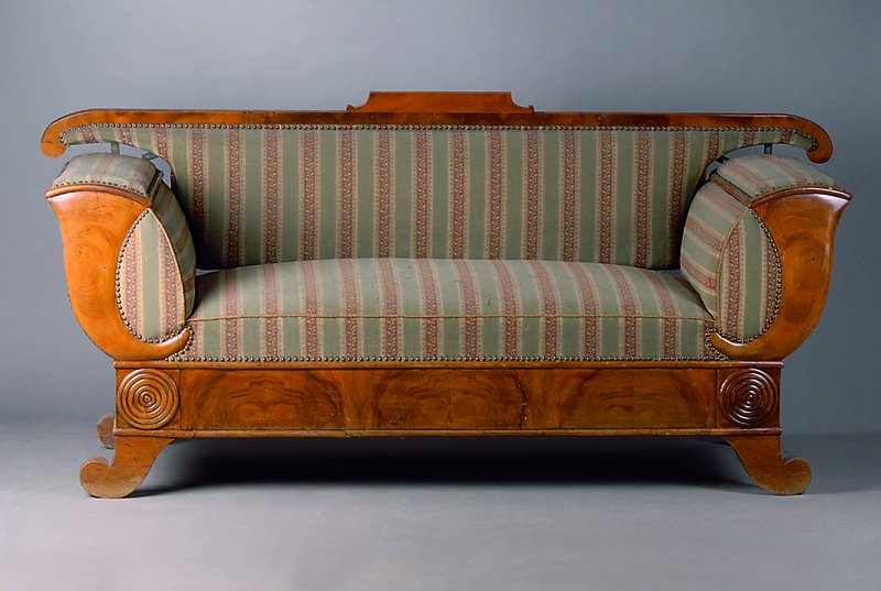 Sofa, Frankfurt, um 1830/40, Nußbaum, allseitig geschweift, sparsame Schnitzereien, gestreifter Bezug, Rückenlehne lose, Schraubenfehlen, st. ...