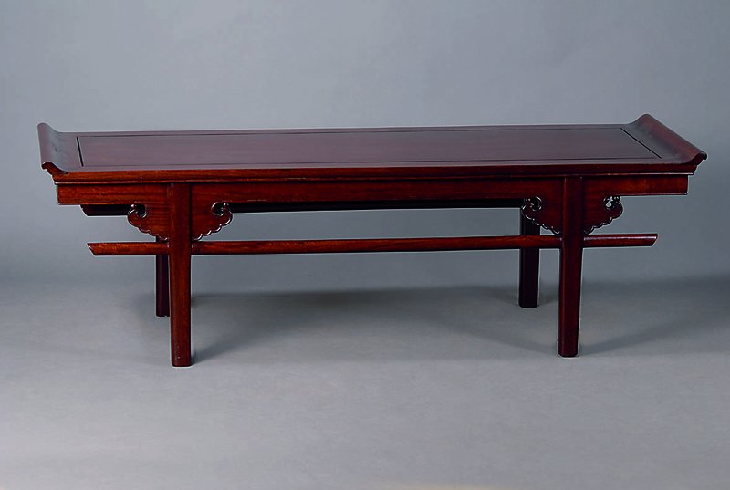 Sofatisch, China 20 Jh., Mahaghoni, sparsame Schnitzereien, Beine teils verstrebt, Gebr.-Sp., ca. 46x156x51 cm