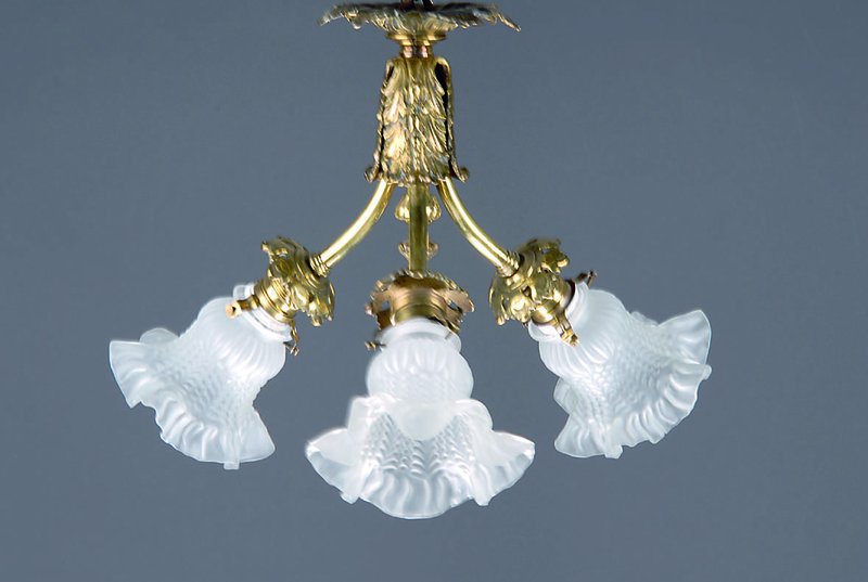 Deckenlampe, deutsch, um 1910/20, Messingmontur mit drei Brennstellen, alte Porzellaneinsätze an den Fassungen, drei Preßglasschirmchen, Elektr. ...