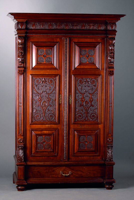 Schrank, deutsch, um 1880/90, Nußbaum, 2 -türig, Inlets mit reicher Flachschnitzerei, 1 Blenderschublade, Lisenen mit plastischen Köpfen, ...