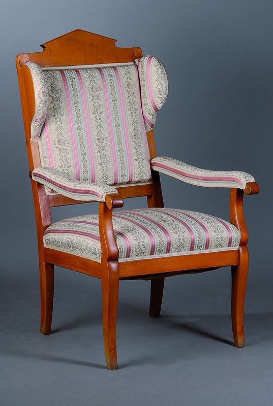 Ohrenbackensessel, süddeutsch, um 1820-25, Kirschbaum, Beine geschweift, Polsterung alt belassen, Bezug sek., Armlehnen in Voluten auslaufend, Reste ...