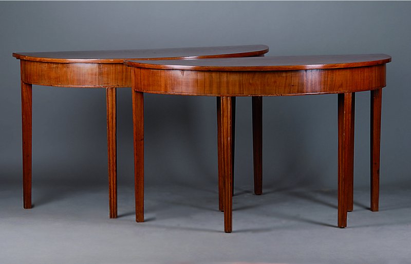 Paar Konsolentische, wohl England, um 1860, Mahagoni, einzeln oder zusammen als runder Tisch stellbar, geriefte Beine, Leistenteile besch., st. ...