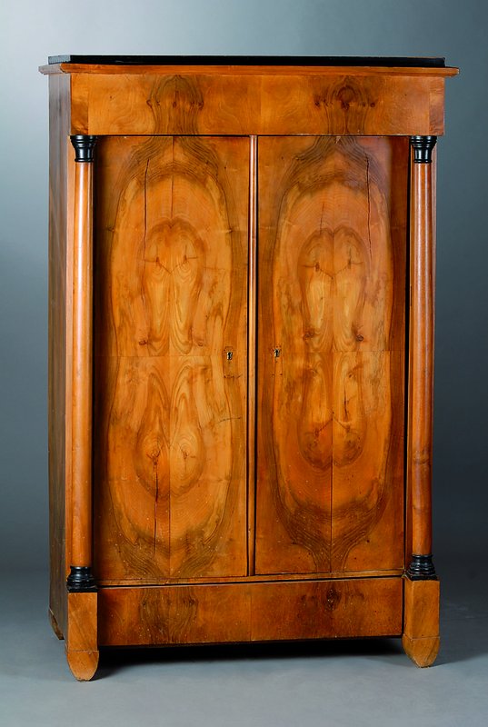 Schrank, süddeutsch, um 1820/30, Korpus WH, Vollsäulen, Nußbaumfurnier gesp. verlegt, schwundrissig, teilrest., 1-türig, schwarze Zierleisten, ...
