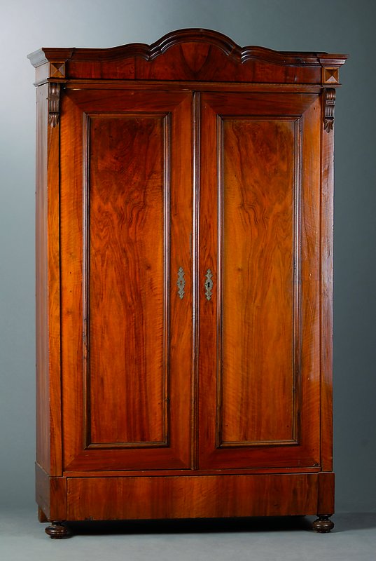 Gründerzeitschrank, deutsch, um 1880/90, Nußbaumfurnier, 2-türig, Fußschublade, Inlets getreppt, Lisenen m. aufgesetzer Volutenverz., Kopf ...