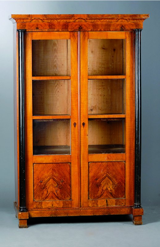 Vitrine, deutsch, um 1820, Biedermeier, Nußbaumfurnier, 2-türig, teilverglast und versprosst, freistehende Säulen geschwärzt, Kopf vielfach ...