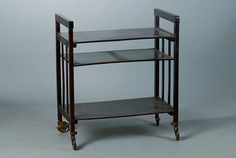 Etagentisch, wohl Wien, um 1905/06, Eiche, auf Rollen, dunkel gebeizt, 3 Ablegefächer, Verleimung empf., Seiten versprosst, st. Gebr.-Sp., ca. ...