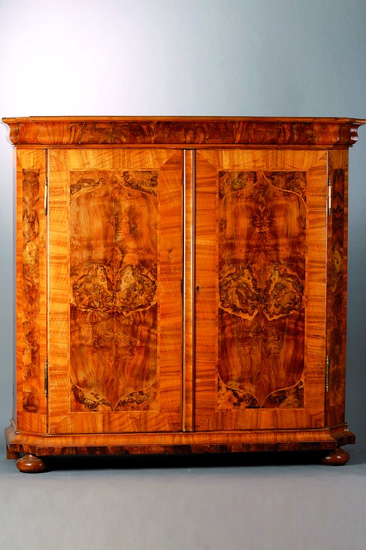 Barockschrank, um 1780, Nußbaum, 2-türig, Türen und Seiten m. Wurzelnußeinlagen gespiegelt verlegt, abgeflachte Ecken, Kopf getreppt, ...