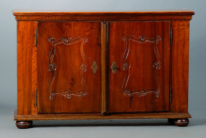 Kleine Anrichte, um 1730/40, aus alten Teilen zusammengesetzt, Nußbaum, 2-türig, Flachschnitzereien in Form v. Voluten, Gebr. -Sp., teilrest., ca. ...