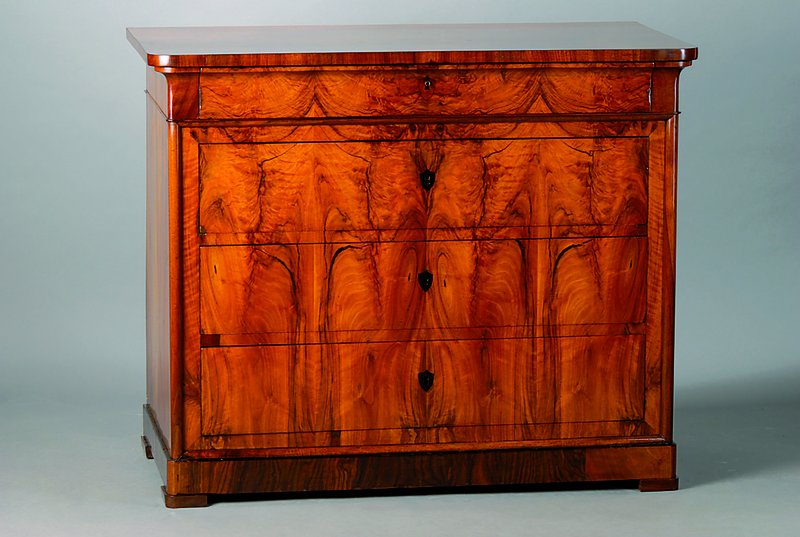 Kommode, Baden, um 1850, Biedermeier, Nußbaumfurnier, Furnier 4-fach gespiegelt verlegt, 4-schübig, abgerundete Ecken, Fuß getreppt, l. Gebr.-Sp., ...