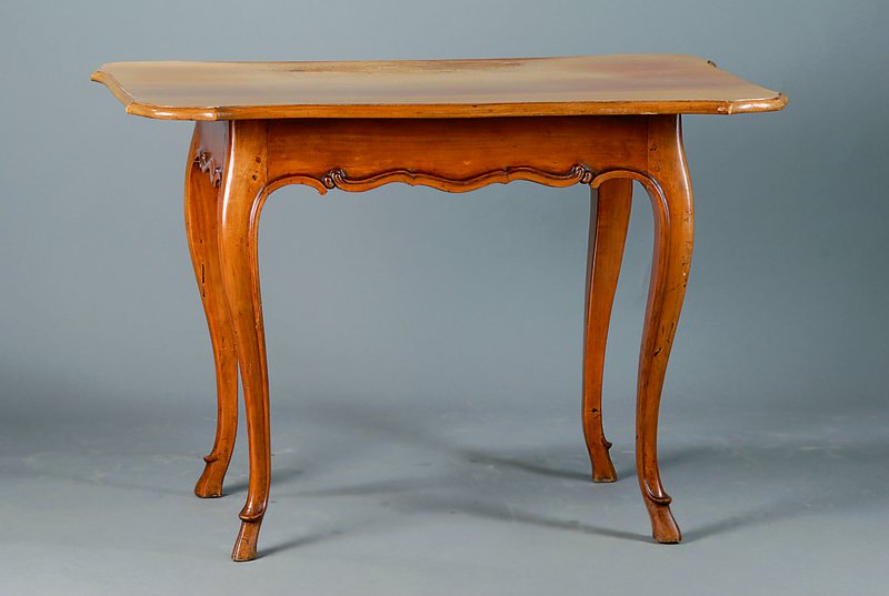 Barocktisch, Pfalz, um 1770, Nußbaum, Platte sek., allseitig geschweift, sparsame Schnitzereien, Platte m. starken Gebr.-Sp., sog. Geißfüße, alt ...