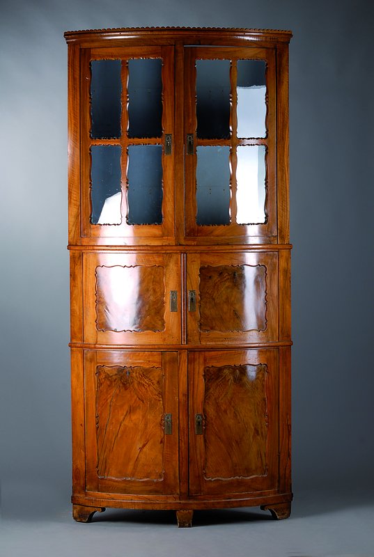 Eckschrank/Ecksekretär, Pfalz, um 1835/40, Nußbaum massiv, Füllungen Wurzelnuß, 2-teilig,Mittelteil mit Sekretärfach, Oberteil verglast und ...