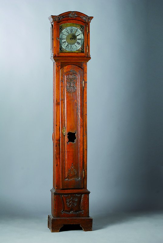 Standuhr, um 1770, Nußbaum/Eiche verziert und geschnitzt, Sockel gekürzt, in Türe Maskeronenpaar, alter Wurmbefall, orig. Beschläge, im Giebel ...