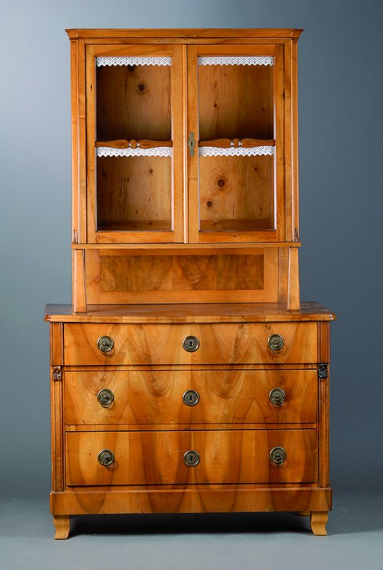 Aufsatzkommode, deutsch, um 1830, Oberteil um 1860 dazugearb., Nußbaumfurnier, Unterteil 3-schübig, Oberteil 2-türig verglast, Teile ergänzt, ...