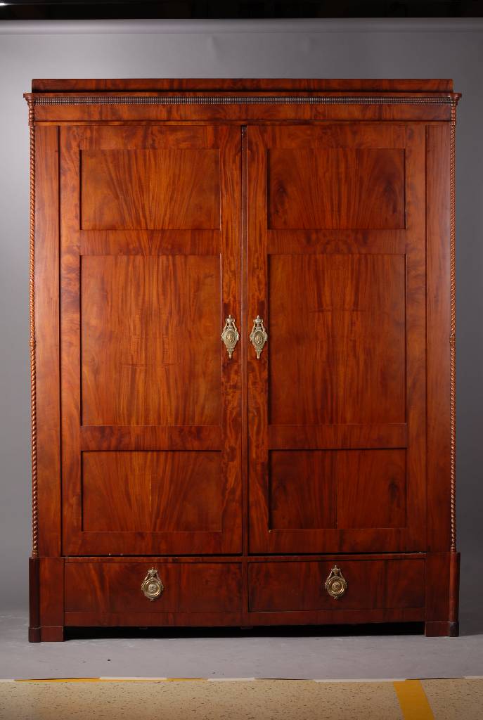 Großer zweitüriger Kleiderschrank, um 1830, Mahagoni furniert, 2-türig, 2 Fußschubladen, Lisenen m. gedrechselten 3/4 Säulen, Kopf m. Zahnfries, ...