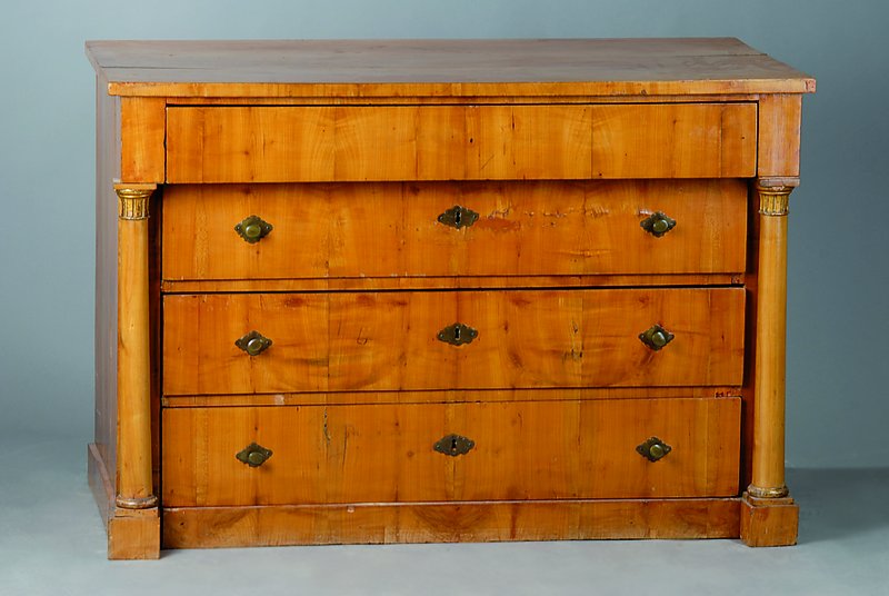 Kommode, 18. Jh., Kirschbaumfurnier, 4-schübig, Lisenen m. Vollsäulen, goldverzierte Abschlüsse, schwundrissig, Furniersch., ohne Schlüssel, ...