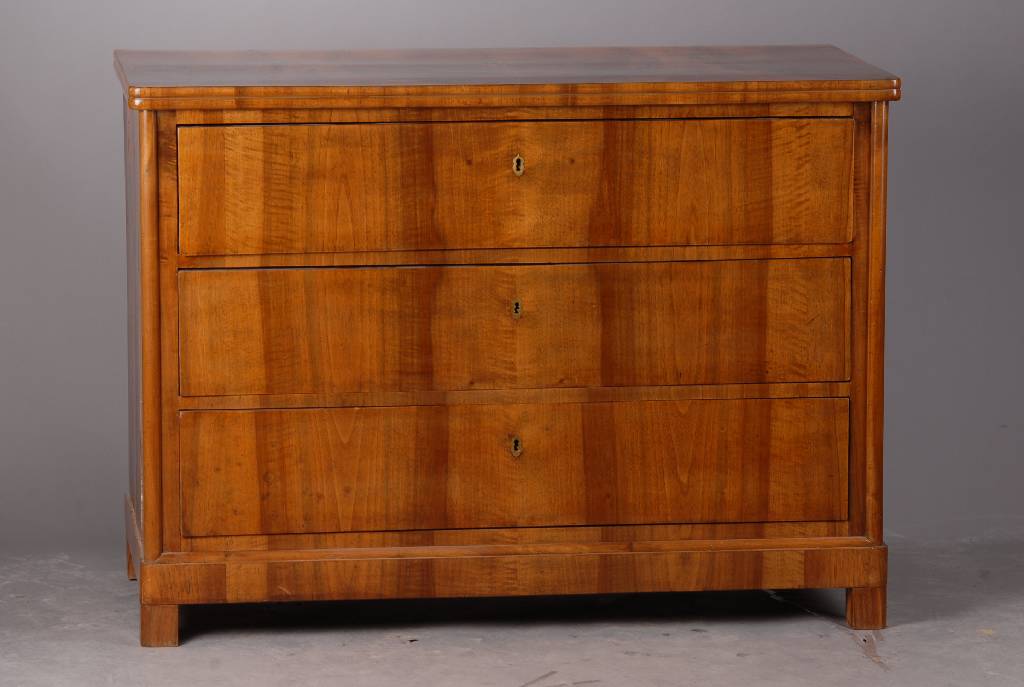 Kommode, Biedermeier, um 1830/40, Nußbaumfurnier, 3-schübig, abgerundete Ecken, l. Furniersch., st. Gebr.-Sp., ca. 86x117x58 cm ohne Schlüssel