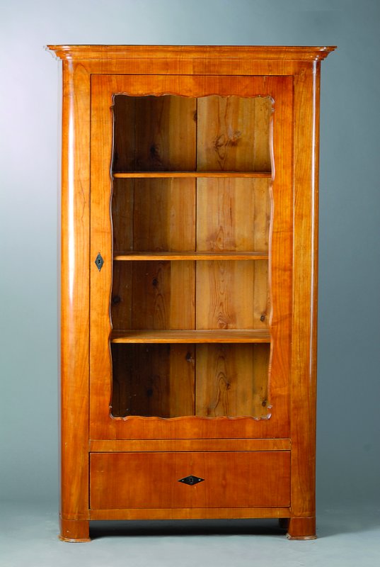 1-türige Vitrine, Biedermeier, um 1835/40, Kirschbaumfurnier, 1-türig verglast, Fußschublade, abgerundete Ecken, Kopf getreppt, Beschl. erneuert, ...