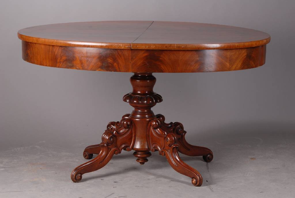 Ausziehtisch, um 1860/70, Mahagonifurnier, reich gedrechselter und geschnitzer Fuß, Einlegebretter fehlen, Oberfläche lackiert, st. Gebr.-Sp., l. ...