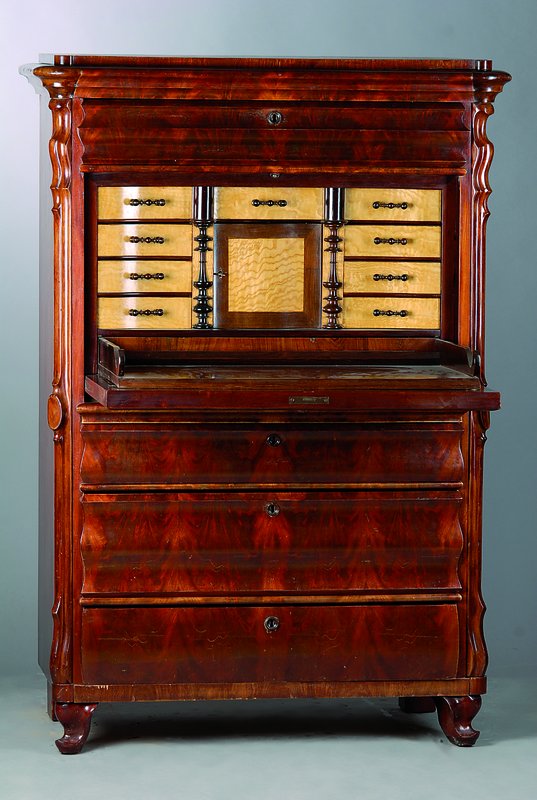 Standsekretär, um 1860/70, Mahagonifurnier, 3-schübig, Klappe, reiche Inneneinrichtung, Kopfschublade, angedeutete Volutenverz., abgerundete Ecken, ...